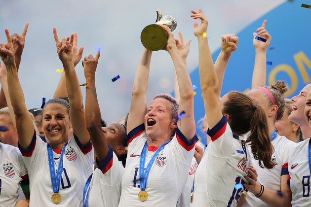 LYON, FRANCE - JULY 07: Megan Rapinoe of USA celebrates victory as she lifts the FIFA Womens World Cup trophy during the 2019 FIFA Women's World Cup France Final match between Winner The United States of America and Netherlands at Stade de Lyon on July 7, 2019 in Lyon, France. (Photo by Molly Darlington - AMA/Getty Images)