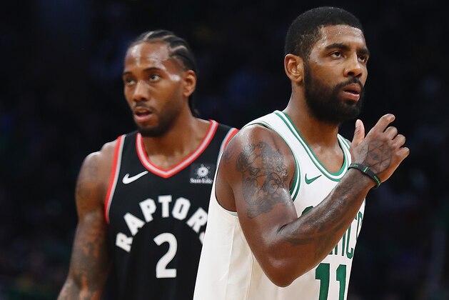 BOSTON, MA - NOVEMBER 16:  Kawhi Leonard #2 of the Toronto Raptors and Kyrie Irving #11 of the Boston Celtics look on during the first half at TD Garden on November 16, 2018 in Boston, Massachusetts.  (Photo by Tim Bradbury/Getty Images)