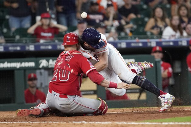 Houston Astros' Jake Marisnick, right, collides Los Angeles Angels catcher Jonathan Lucroy (20) while trying to score during the eighth inning of a baseball game Sunday, July 7, 2019, in Houston. Marisnick was called out under the home plate collision rule. (AP Photo/David J. Phillip)