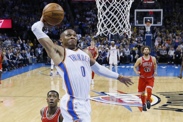 Oklahoma City Thunder guard Russell Westbrook (0) goes up for a dunk in front of Chicago Bulls guard Kris Dunn, left, and center Robin Lopez (42) in the second quarter of an NBA basketball game in Oklahoma City, Wednesday, Nov. 15, 2017. (AP Photo/Sue Ogrocki)