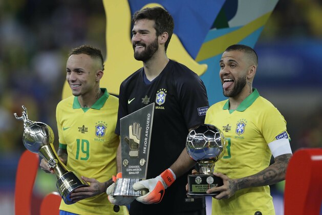Brazil's Everton, left, holds his Top Scorer trophy as he poses with teammates goalkeeper Alisson holding his Best Goalkeeper trophy and Brazil's Dani Alves holding his top scorer trophy, after their 3-1 victory over Peru in the final match of the Copa America at Maracana stadium in Rio de Janeiro, Brazil, Sunday, July 7, 2019. (AP Photo/Silvia Izquierdo)
