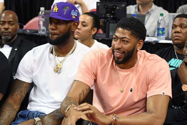 LAS VEGAS, NEVADA - JULY 05:  NBA players LeBron James (L) and Anthony Davis watch a game between the New Orleans Pelicans and the New York Knicks during the 2019 NBA Summer League at the Thomas & Mack Center on July 5, 2019 in Las Vegas, Nevada. NOTE TO USER: User expressly acknowledges and agrees that, by downloading and or using this photograph, User is consenting to the terms and conditions of the Getty Images License Agreement.  (Photo by Ethan Miller/Getty Images)