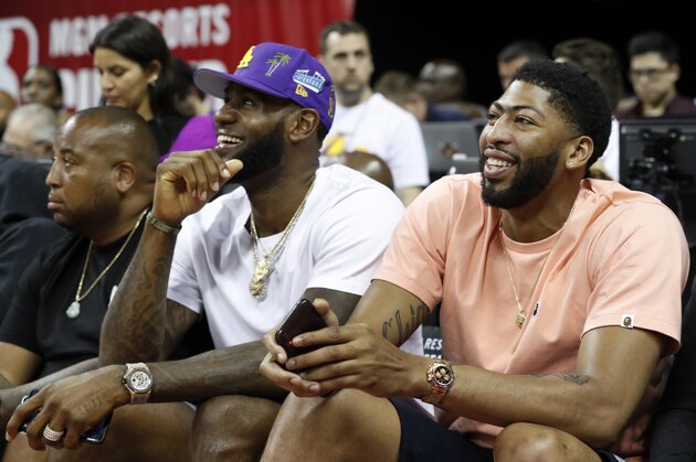 Los Angeles Laker players LeBron James, center, and Anthony Davis, right, take in an NBA summer league basketball game between the New York Knicks and the New Orleans Pelicans, Friday, July 5, 2019, in Las Vegas. (AP Photo/Steve Marcus)