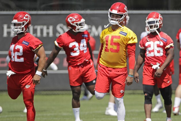 Kansas City Chiefs running backs Anthony Sherman (42), Carlos Hyde (34) and Damien Williams (26) stretch with quarterback Patrick Mahomes (15) during a workout at the NFL football team's training facility Thursday, June 13, 2019, in Kansas City, Mo. (AP Photo/Charlie Riedel)