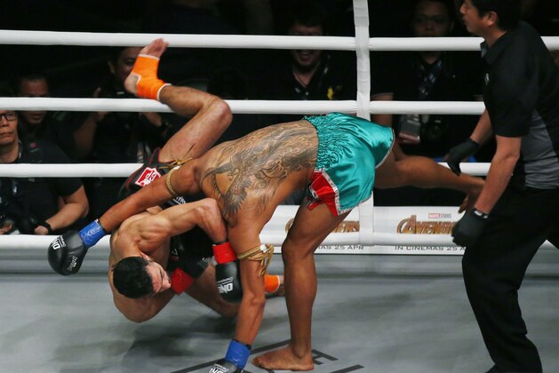 Thailand's Jo Nattawut, right, floors opponent Giorgio Petrosyan, of Italy, during their ONE Championship kickboxing bout Friday, April 20, 2018, at Mall of Asia Arena in suburban Pasay city south of Manila, Philippines. ONE Championship, Asia's premier martial arts organization, introduced the new ring instead of the octagon cage. Petrosyan won the bout via unanimous decision. (AP Photo/Bullit Marquez)