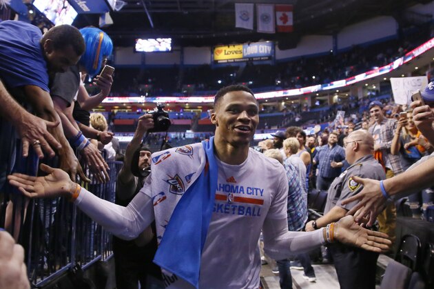 Oklahoma City Thunder guard Russell Westbrook slaps hands with fans as he leaves the floor after an NBA basketball game against the Milwaukee Bucks in which he tied the record for triple-doubles in a season in Oklahoma City, Tuesday, April 4, 2017. Oklahoma City won 110-79. (AP Photo/Sue Ogrocki)