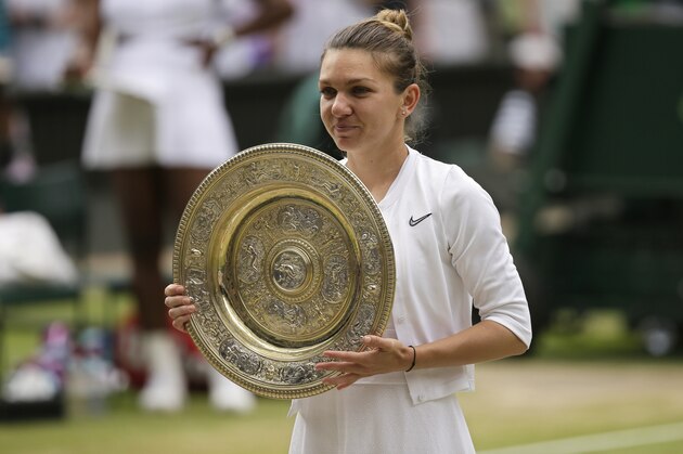 Romania's Simona Halep holds her trophy after defeating United States' Serena Williams in the women's singles final match on day twelve of the Wimbledon Tennis Championships in London, Saturday, July 13, 2019. (AP Photo/Tim Ireland)