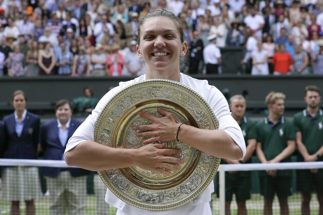 Romania's Simona Halep poses with the trophy after defeating United States' Serena Williams during the women's singles final match on day twelve of the Wimbledon Tennis Championships in London, Saturday, July 13, 2019. (AP Photo/Kirsty Wigglesworth)