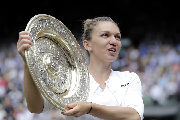 Romania's Simona Halep holds the trophy after defeating United States' Serena Williams during the women's singles final match on day twelve of the Wimbledon Tennis Championships in London, Saturday, July 13, 2019. (AP Photo/Ben Curtis)