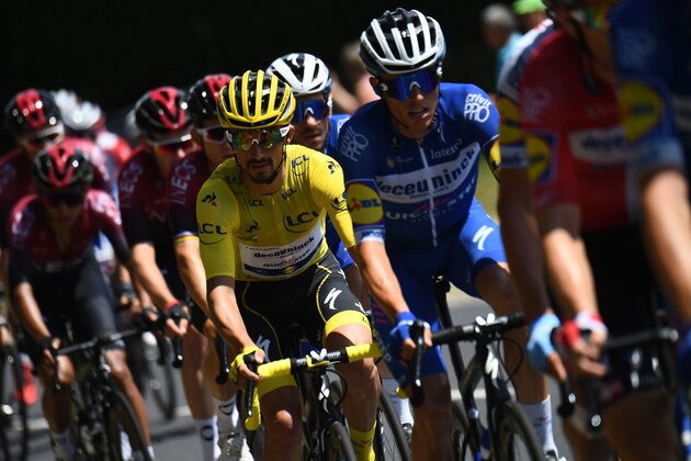 France's Julian Alaphilippe (C), wearing the overall leader's yellow jersey rides in the pack during the ninth stage of the 106th edition of the Tour de France cycling race between Saint-Etienne and Brioude, on July 14, 2019. (Photo by Anne-Christine POUJOULAT / AFP)        (Photo credit should read ANNE-CHRISTINE POUJOULAT/AFP/Getty Images)