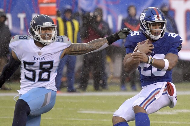 New York Giants running back Saquon Barkley (26) avoids a tackle from Tennessee Titans linebacker Harold Landry (58) during the first half of an NFL football game, Sunday, Dec. 16, 2018, in East Rutherford, N.J. (AP Photo/Bill Kostroun)