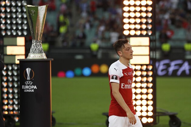 Arsenal's Mesut Ozil walks past the trophy after receiving his second place medal after the Europa League Final soccer match between Chelsea and Arsenal at the Olympic stadium in Baku, Azerbaijan, Thursday, May 30, 2019. Chelsea won 4-1. (AP Photo/Darko Bandic)