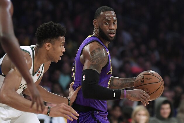 Los Angeles Lakers forward LeBron James, right, tries to move past Milwaukee Bucks forward Giannis Antetokounmpo during the first half of an NBA basketball game Friday, March 1, 2019, in Los Angeles. (AP Photo/Mark J. Terrill)