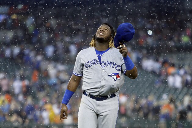 Toronto Blue Jays' Vladimir Guerrero Jr., with his glove tucked inside his uniform, walks off the field after a rain delay was called during the fourth inning of a baseball game against the Detroit Tigers, Saturday, July 20, 2019, in Detroit. (AP Photo/Duane Burleson)