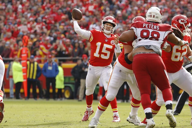 Kansas City Chiefs quarterback Patrick Mahomes (15) throws a touchdown pass to wide receiver Tyreek Hill as offensive lineman Andrew Wylie (77) blocks Arizona Cardinals defensive tackle Corey Peters (98) during the first half of an NFL football game in Kansas City, Mo., Sunday, Nov. 11, 2018. (AP Photo/Charlie Riedel)