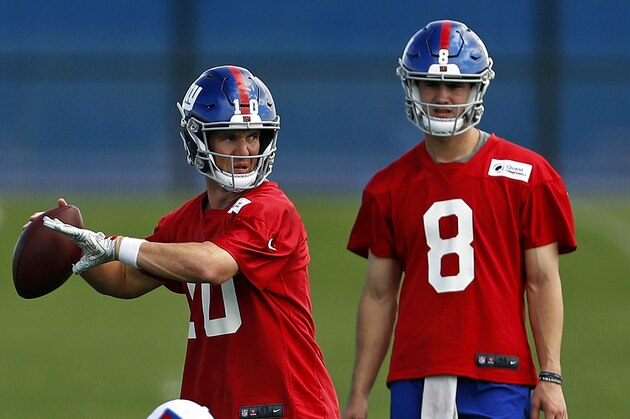 New York Giants quarterback Eli Manning passes in front of quarterback Daniel Jones during an NFL football practice Monday, May 20, 2019, in East Rutherford, N.J. (AP Photo/Adam Hunger)