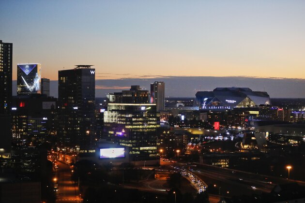 The sun sets behind Mercedes-Benz Stadium and the downtown skyline ahead of Sunday's NFL Super Bowl 53 football game between the Los Angeles Rams and New England Patriots in Atlanta, Friday, Feb. 1, 2019. (AP Photo/David Goldman)