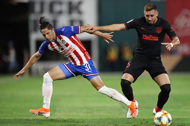 ARLINGTON, TEXAS - JULY 23:  Alan Cervantes #31 of Guadalajara and Hector Herrera #16 of Atletico Madrid battle for the ball during their 2019 International Champions Cup match at Globe Life Park in Arlington on July 23, 2019 in Arlington, Texas. (Photo by Ronald Martinez/International Champions Cup via Getty Images)