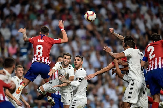 Atletico Madrid's Spanish midfielder Saul Niguez (L) jumps for the ballnext to Real Madrid's Spanish defender Nacho Fernandez and Real Madrid's Spanish defender Sergio Ramos during the Spanish league football match between Real Madrid CF and Club Atletico de Madrid at the Santiago Bernabeu stadium in Madrid on September 29, 2018. (Photo by OSCAR DEL POZO / AFP)        (Photo credit should read OSCAR DEL POZO/AFP/Getty Images)