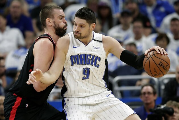 Orlando Magic's Nikola Vucevic (9) tries to get past Toronto Raptors' Marc Gasol during the first half in Game 3 of a first-round NBA basketball playoff series, Friday, April 19, 2019, in Orlando, Fla. (AP Photo/John Raoux)