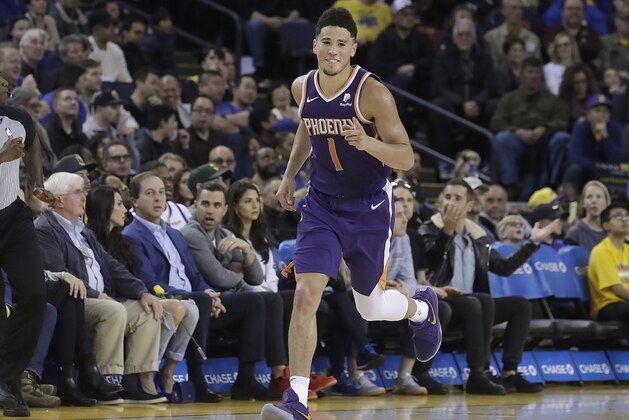 Phoenix Suns guard Devin Booker (1) gestures after scoring against the Golden State Warriors during the second half of an NBA basketball game in Oakland, Calif., Sunday, March 10, 2019. (AP Photo/Jeff Chiu)
