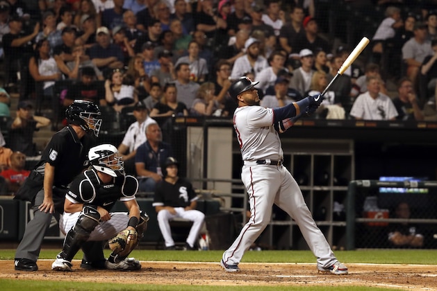 Minnesota Twins' Nelson Cruz watches his two run home run during the fifth inning of a baseball game as Chicago White Sox catcher James McCann (33) and home plate umpire Ed Hickox (15) look on Thursday, July 25, 2019, in Chicago. It was Cruz's third home run of the game. (AP Photo/Jeff Haynes)