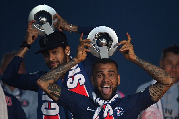Paris Saint-Germain's Brazilian forward Neymar and Paris Saint-Germain's Brazilian defender Dani Alves (R) celebrate with their Champion's trophy at the end of the French L1 football match between Paris Saint-Germain (PSG) and Dijon at the Parc des Princes stadium in Paris on May 18, 2019. (Photo by FRANCK FIFE / AFP)        (Photo credit should read FRANCK FIFE/AFP/Getty Images)