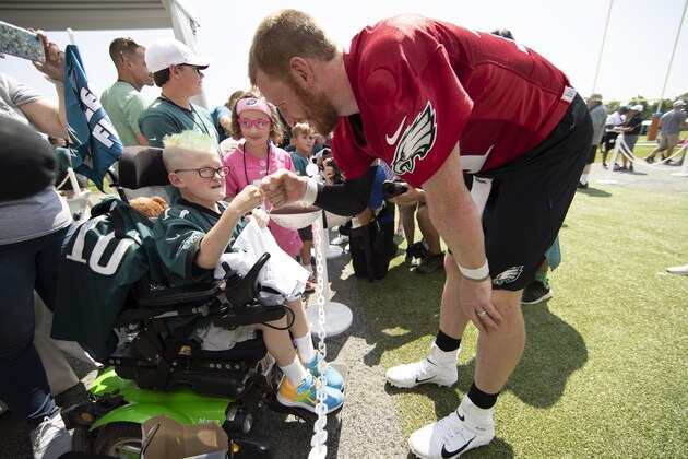 Philadelphia Eagles quarterback Carson Wentz bumps fists with eleven-year-old Giovanni Hamilton who is attending the practice as part of a wish granted by Bianca's Kids at the NFL football team's training camp in Philadelphia, Friday, July 26, 2019. (AP Photo/Matt Rourke)