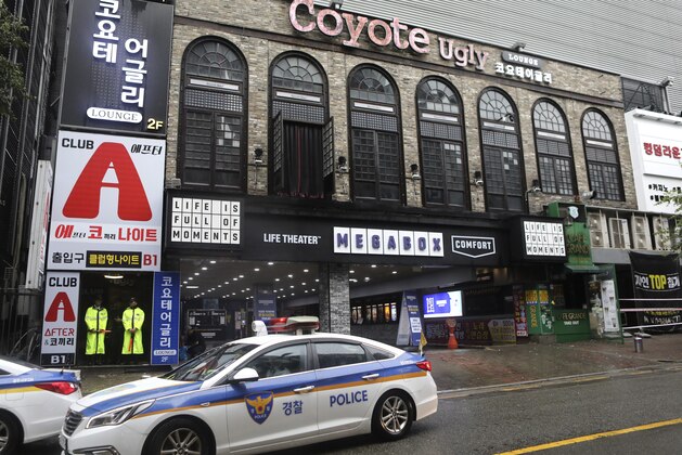 Police stand at the door to a nightclub in Gwangju, South Korea, Saturday, July 27, 2019. Members of the U.S. national water polo team were in a South Korean nightclub on Saturday when an internal balcony collapsed, killing at least one person. A local news agency has reported that one person has died, with 13 injured. No U.S. swimmers were at the club at the time. (AP Photo/Lee Jin-man)
