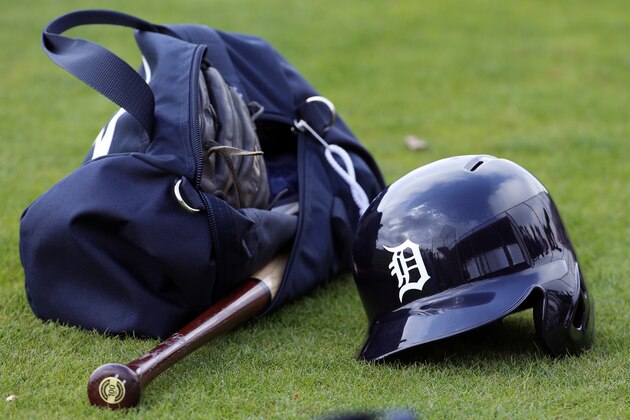 A Detroit Tigers batting helmet and equipment bag in the grass on a practice field during a spring training baseball workout  in Lakeland, Fla., Tuesday, Feb. 24, 2015.  (AP Photo/Gene J. Puskar)