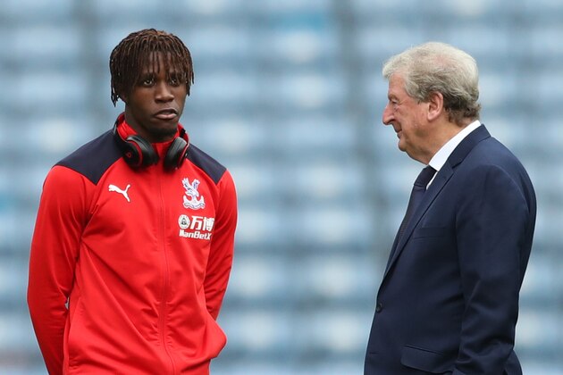 HUDDERSFIELD, ENGLAND - SEPTEMBER 15:  Wilfried Zaha of Crystal Palace (R) and Roy Hodgson, Manager of Crystal Palace speak ahead of the Premier League match between Huddersfield Town and Crystal Palace at John Smith's Stadium on September 15, 2018 in Huddersfield, United Kingdom.  (Photo by Mark Robinson/Getty Images)