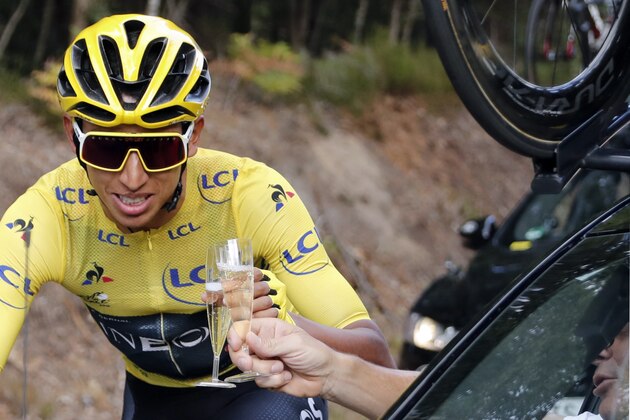 Colombia's Egan Bernal wearing the overall leader's yellow jersey toasts with champagne with the team staff sit in the car, during the 21st and last stage of the 106th edition of the Tour de France cycling race between Rambouillet and Paris Champs-Elysees, in Paris, on July 28, 2019. (Photo by Thibault Camus / POOL / AFP)        (Photo credit should read THIBAULT CAMUS/AFP/Getty Images)