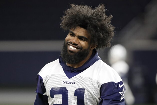 Dallas Cowboys running back Ezekiel Elliott smiles as he walks off the field after participating in drills at the team's NFL football training facility in Frisco, Texas, Wednesday, June 12, 2019. (AP Photo/Tony Gutierrez