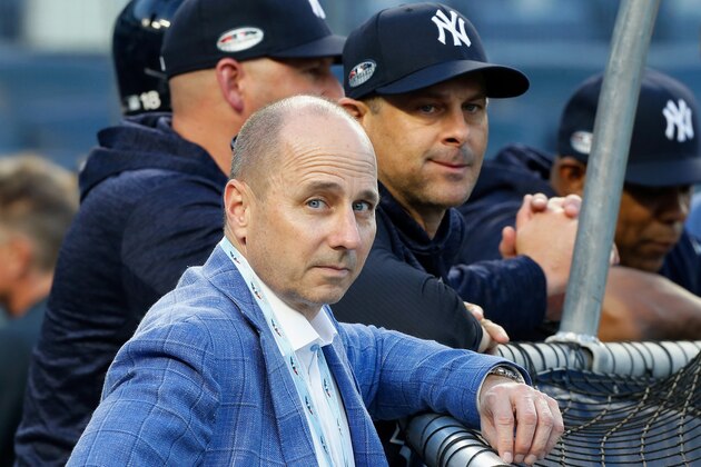 NEW YORK, NY - OCTOBER 09:  (NEW YORK DAILIES OUT)   General Manager Brian Cashman and Manager Aaron Boone #17 of the New York Yankees during batting practice before Game Four of the American League Division Series against the Boston Red Sox at Yankee Stadium on October 9, 2018 in the Bronx borough of New York City. The Red Sox defeated the Yankees  4-3.  (Photo by Jim McIsaac/Getty Images)