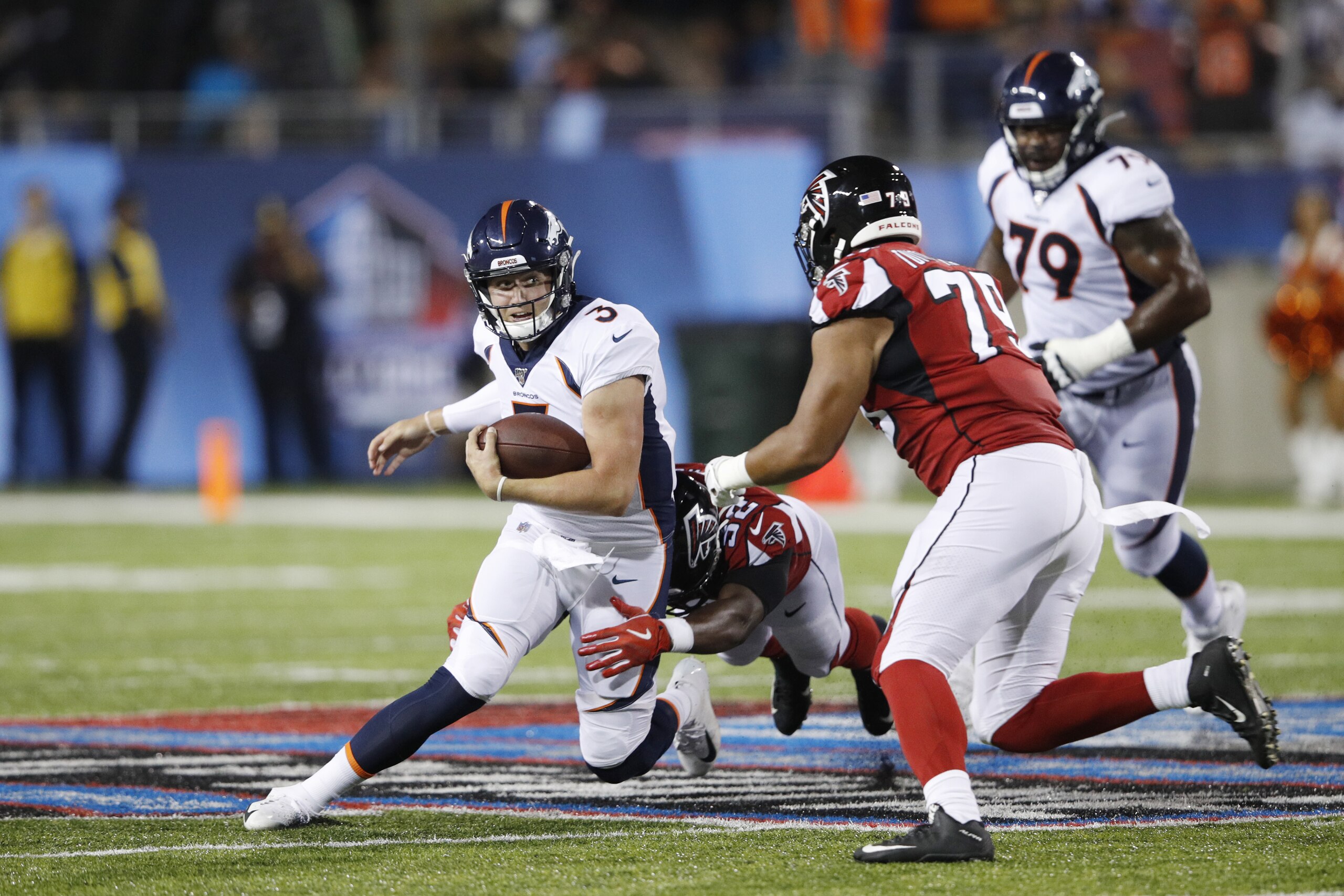 CANTON, OH - AUGUST 01: Drew Lock #3 of the Denver Broncos tries to avoid pressure in the first half of a preseason game against the Atlanta Falcons at Tom Benson Hall Of Fame Stadium on August 1, 2019 in Canton, Ohio. (Photo by Joe Robbins/Getty Images)