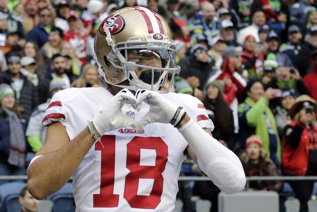 San Francisco 49ers wide receiver Dante Pettis (18) makes a heart shape with his hands after he scored a touchdown against the Seattle Seahawks during the second half of an NFL football game, Sunday, Dec. 2, 2018, in Seattle. (AP Photo/John Froschauer)