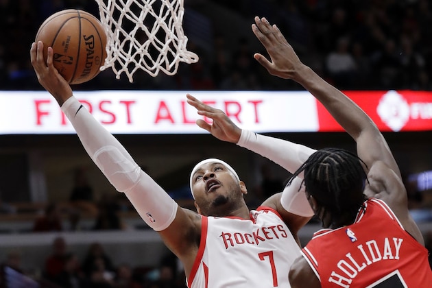 Houston Rockets forward Carmelo Anthony, left, drives to the basket against Chicago Bulls forward Justin Holiday during the first half of an NBA basketball game Saturday, Nov. 3, 2018, in Chicago. (AP Photo/Nam Y. Huh)