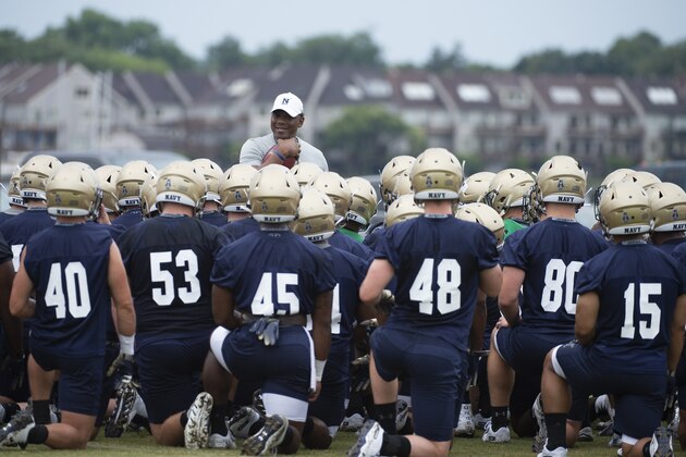 Navy offensive coordinator Ivin Jasper, center, speaks with the offense during work outs for NCAA college football training camp, Friday, Aug. 2, 2019, in Annapolis, Md. (AP Photo/Tommy Gilligan)