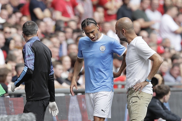 Manchester City's Leroy Sane, left, grimaces walking by Manchester City's manager Pep Guardiola as he leaves the pitch after an injury during the English Community Shield soccer match between Liverpool and Manchester City at Wembley stadium in London, Sunday, Aug. 4, 2019. (AP Photo/Kirsty Wigglesworth)