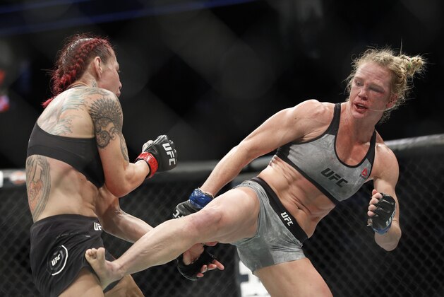 Holly Holm kicks Cris Cyborg during a featherweight championship mixed martial arts bout at UFC 219, Saturday, Dec. 30, 2017, in Las Vegas. (AP Photo/John Locher)
