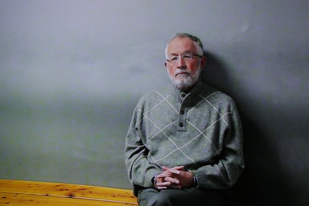 William Strampel appears on a monitor during his video arraignment, Tuesday, March 27, 2018, in East Lansing, Mich. Strampel, a Michigan State University official who oversaw Larry Nassar, was arrested Monday amid an investigation into the handling of complaints against the former sport doctor, who is in prison for sexually assaulting patients under the guise of treatment. (AP Photo/Paul Sancya)