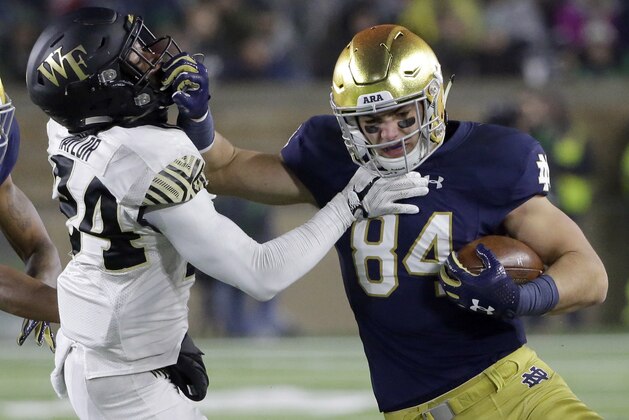 FILE - In this Nov. 4, 2017, file photo, Notre Dame tight end Cole Kmet, right, runs with the ball against Wake Forest defensive back Ja'Sir Taylor during the second half of an NCAA college football game in South Bend, Ind. Notre Dame football coach Brian Kelly offered freshman tight end Cole Kmet a day off last Saturday. It came 12 hours after Kmet earned his third save of the season, striking out one and allowing one hit in two-thirds of an inning of Notre Dame’s 5-2 baseball victory over Wake Forest. (AP Photo/Nam Y. Huh, File)