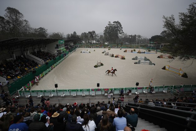 Lucy Deslauriers competes for the United States on her horse Hester in the first classification round of individual and team equestrian jumping at the Pan American Games in Lima, Peru, Tuesday, Aug. 6, 2019. Her father Mario Deslauriers, who is one of her coaches, was competing against her in the same event for Canada. (AP Photo/Rebecca Blackwell)