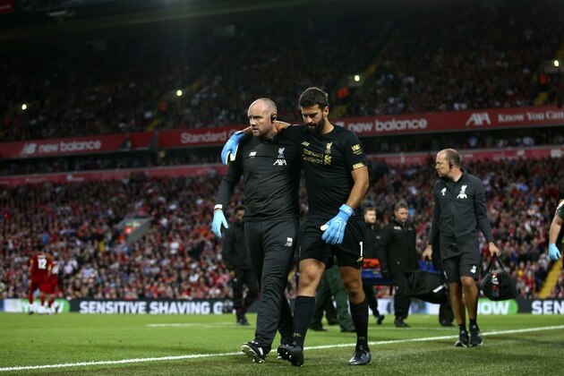 Liverpool's goalkeeper Alisson Becker, right, reacts as he leaves the pitch after an injury during the English Premier League soccer match between Liverpool and Norwich City at Anfield in Liverpool, England, Friday, Aug. 9, 2019. (AP Photo/Dave Thompson)