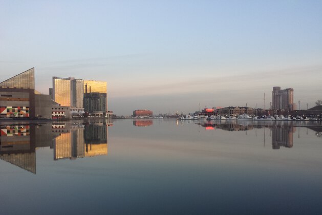 The skyline of Baltimore, Maryland, is reflected in a still and icy Inner Harbor on January 31, 2014.    AFP PHOTO/Michelle KWAJAFA        (Photo credit should read MICHELLE KWAJAFA/AFP/Getty Images)