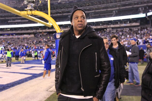 Entertainer Jay-Z walks along the sidelines before an NFL football game between the Dallas Cowboys and the New York Giants, Sunday, Nov. 23, 2014, in East Rutherford, N.J. (AP Photo/Julio Cortez)