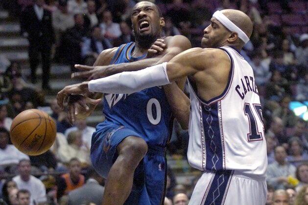 Washington Wizards' Gilbert Arenas (0) is fouled by New Jersey Nets' Vince Carter as he drives to the basket during second quarter NBA basketball Tuesday night, Feb. 27, 2007 in East Rutherford, N.J. (AP Photo/Bill Kostroun)