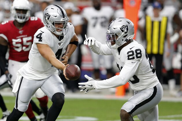 Oakland Raiders quarterback Derek Carr (4) hands off to running back Josh Jacobs (28) during the first half of an an NFL football game against the Arizona Cardinals, Thursday, Aug. 15, 2019, in Glendale, Ariz. (AP Photo/Ralph Freso)