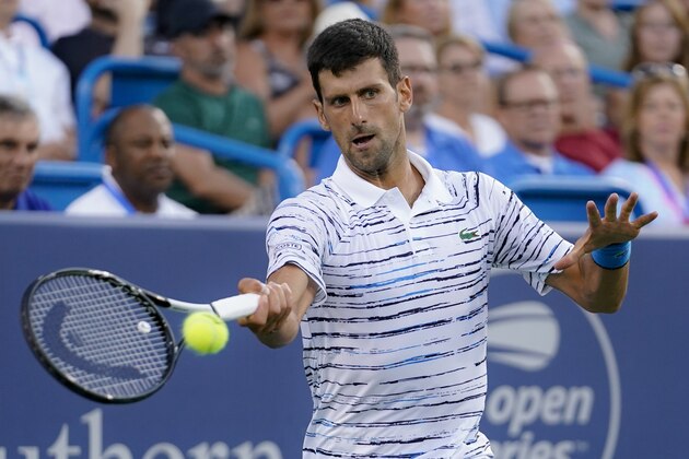 Novak Djokovic, of Serbia, returns to Pablo Carreno Busta, of Spain, during the quarterfinals of the Western & Southern Open tennis tournament Thursday, Aug. 15, 2019, in Mason, Ohio. (AP Photo/John Minchillo)