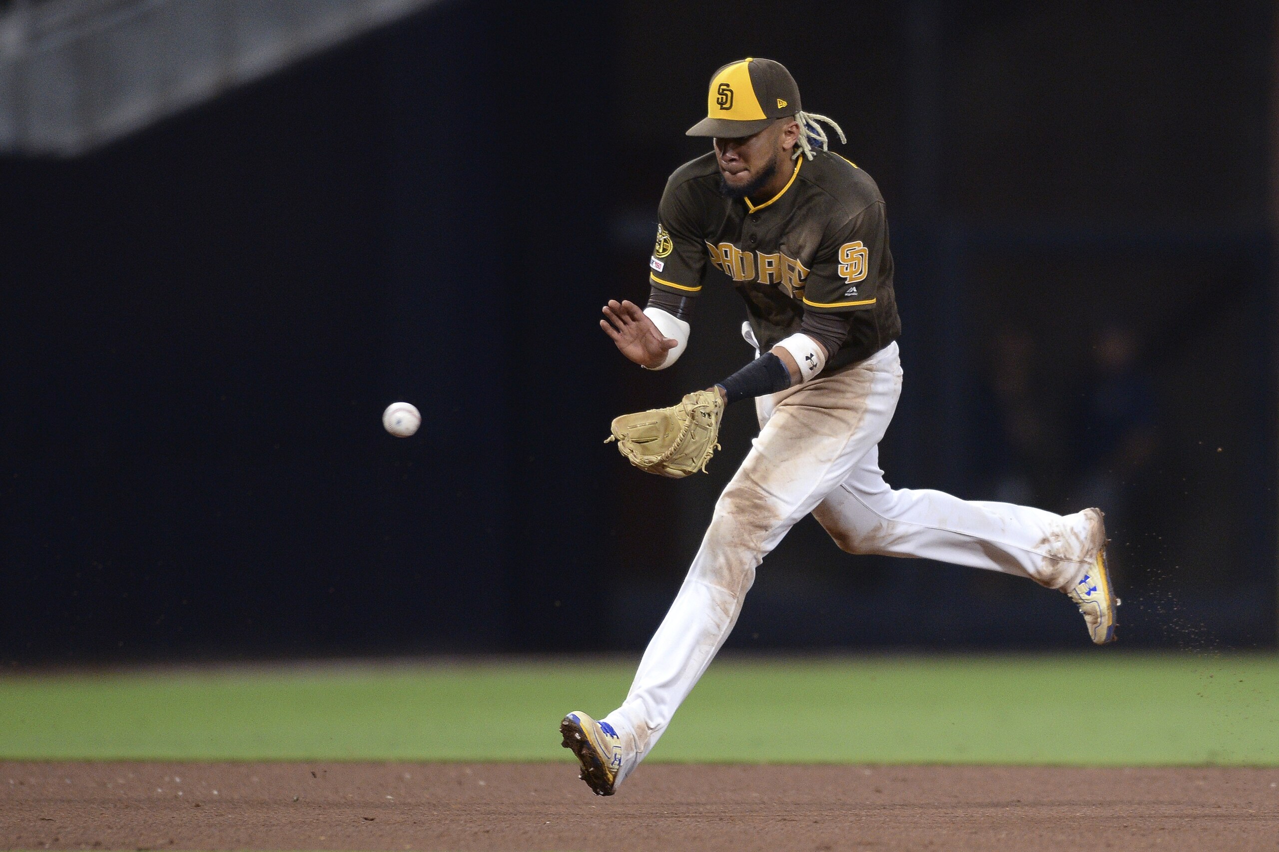 San Diego Padres shortstop Fernando Tatis Jr. fields a ground ball during the ninth inning of the baseball game against the Colorado Rockies Friday, Aug. 9, 2019, in San Diego. The Padres won 7-1. (AP Photo/Orlando Ramirez)